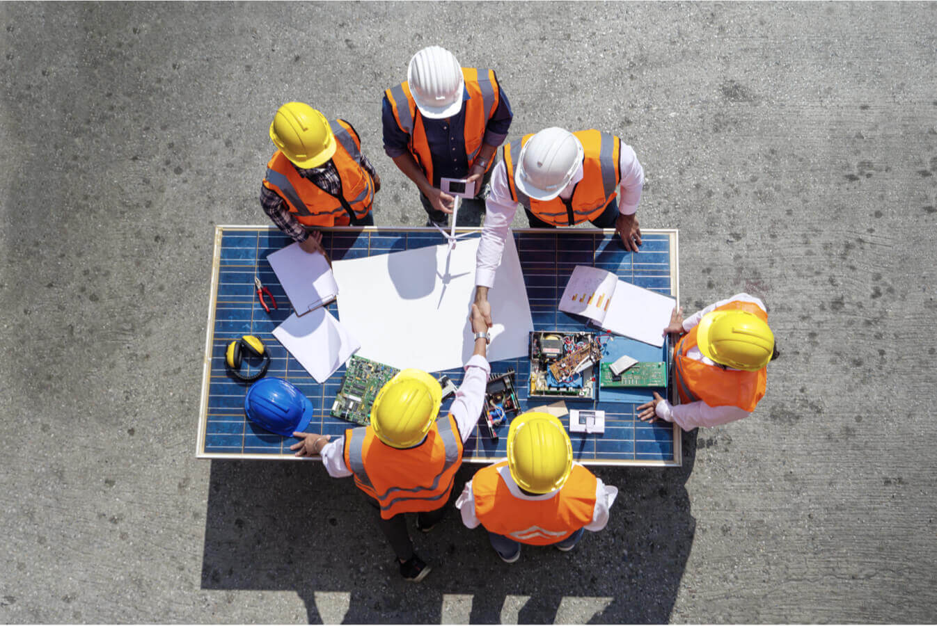 Workers having an outdoor meeting around a table made from a solar panel